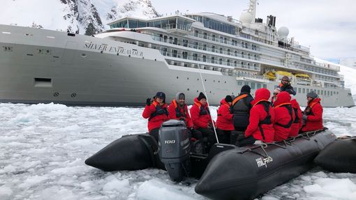 Passengers in Zodiacs observing the renaming ceremony of the Silver Endeavour in Antarctica.