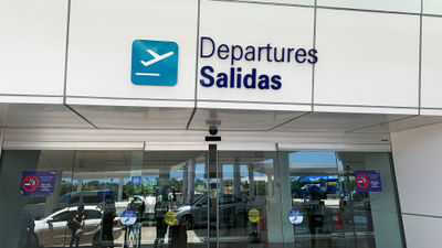 A departures sign at Cancun International Airport.
